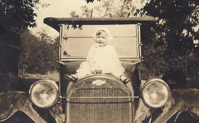 old family photo of baby on car